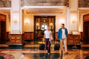Two people with luggage in a Viennese hotel