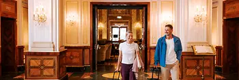 Two people with luggage in a Viennese hotel