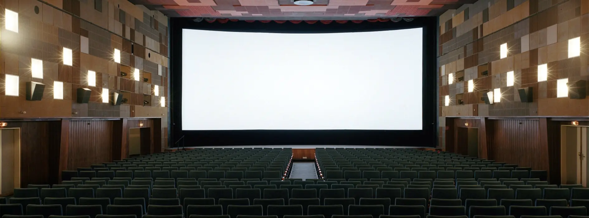 Cinema hall with open curtain, wide screen visible