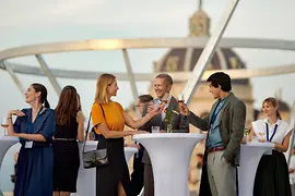 People standing at tall tables on the terrace