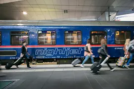 ÖBB Nightjet in the station with travelers in the foreground