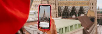 Frau mit Smartphone und Stephansdom im Hintergrund