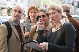 Gruppe mit einer Person mit Stift und Papier in der Hand