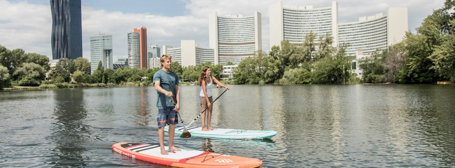 Zwei Personen stand up paddeling auf der Donau