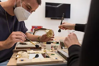 People with brushes at workshop