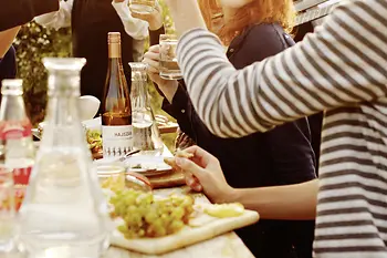 Gruppe am Tisch mit Essen und Trinken