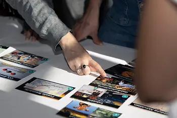 Die Hand einer Person mit Klima Puzzle Karten