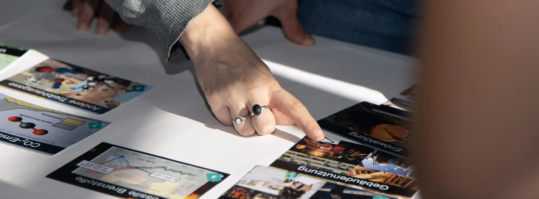 Die Hand einer Person mit Klima Puzzle Karten