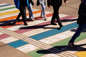 People walking over a rainbow zebra crossing in Vienna