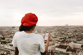 Woman holding a smartphone looks at Vienna from above