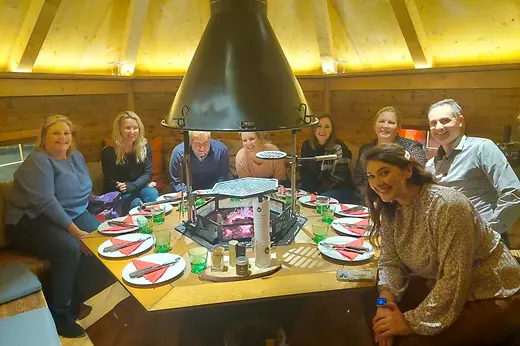 People sitting around an open barbecue