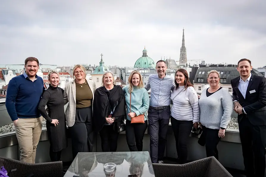 Group photo on balcony with Vienna backdrop