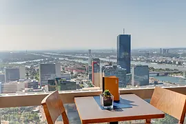 Coffee house table at the glass wall with Vienna panorama in the background