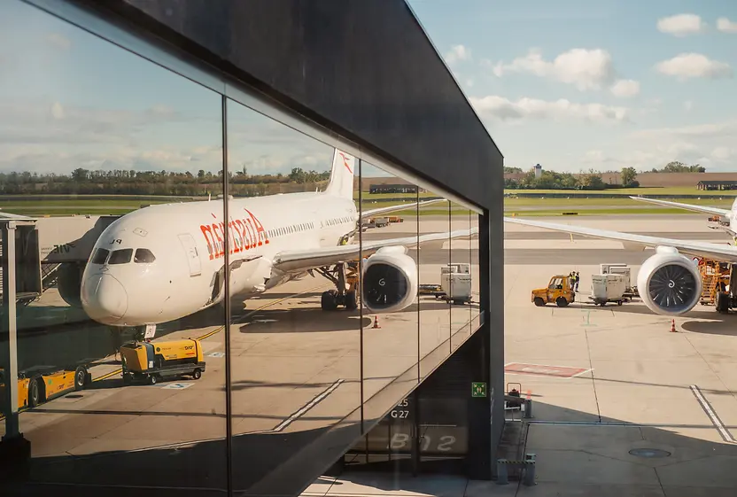 Flugzeug am Flughafen Wien spiegelt sich in Glasfassade des Terminals