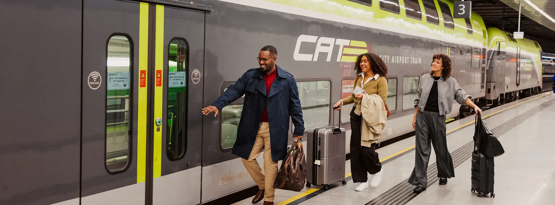 Zwei Damen und ein Herr beim Einsteigen in den Flughafen-Express Zug City Airport Train. 
