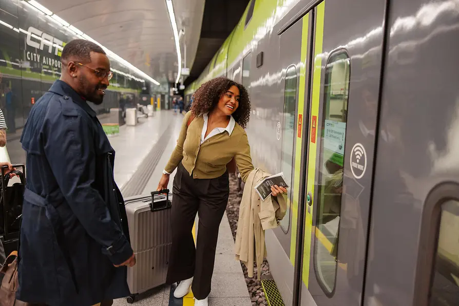 Two people boarding the City Airport Train