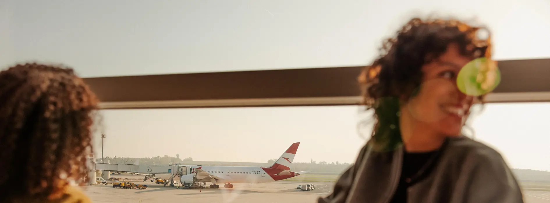Two women at Vienna Airport looking out of the window onto the runway