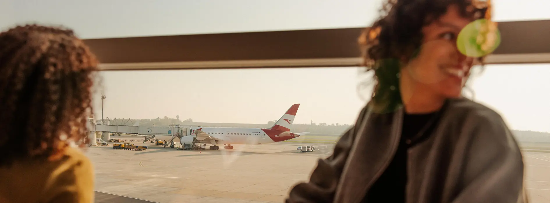 Two women at Vienna Airport looking out of the window onto the runway
