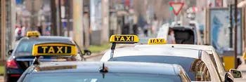 Cab rank in Vienna on the Ringstrasse with several cabs with signs (black with yellow lettering)